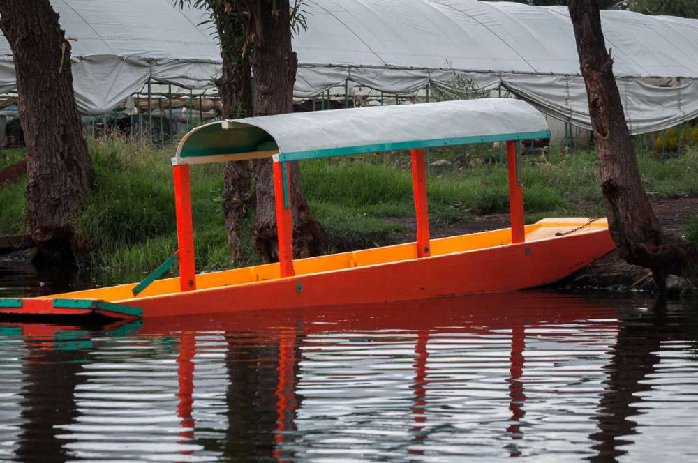 A boat at Xochimilco tied up along the shore.