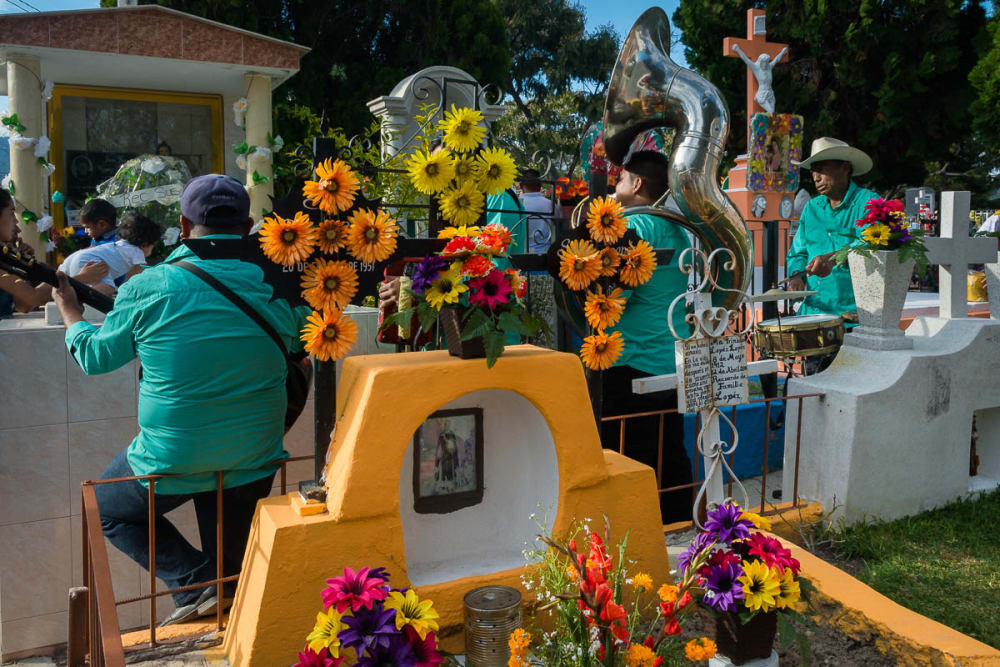 Musicians play for a family mourning during the Day of the Dead in Chapala, Jalisco, Mexico.