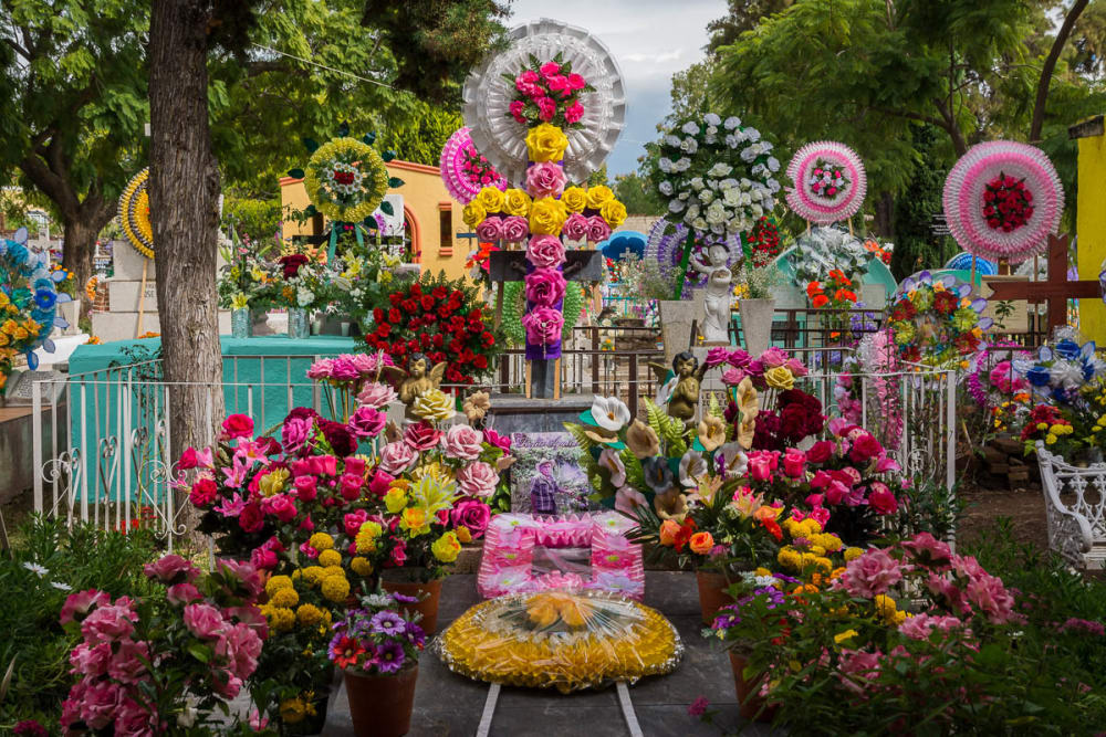 Flower arrangements and coronas line a tomb in the graveyard in San Antonio Tlayacapan.