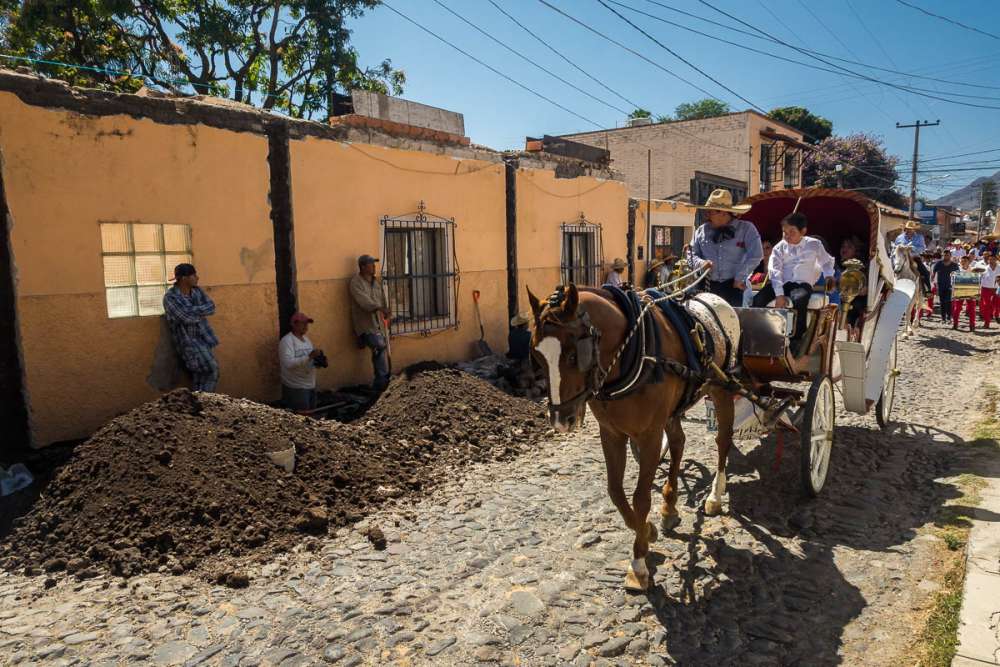 Construction workers watch the procession pass in Ajijic.