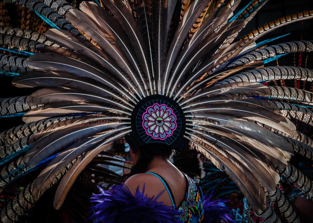 An Aztec dancer wears a large copili headdress made from peacock and turkey feathers during the Fiesta of the Virgin of the Rosary. The Virgin of the Rosary is the town's patroness and has the month of October devoted to her with fireworks, more firework, even more fireworks, and a final procession through bearing an image of the virgin through the town on October 31.