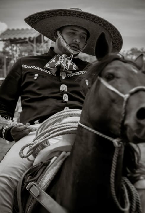 A cowboy plays a game of darts on horseback during el Diá del Charro.