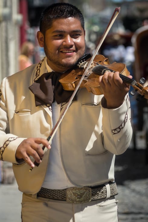 A violinist in a mariachi group performing for a quinceañera.