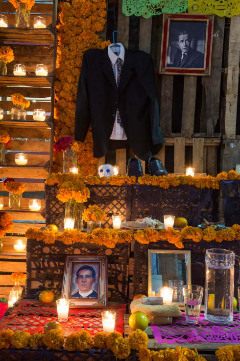 Candles on a Day of the Dead altar for Humphrey Bogart and Santo Toribio Romo.