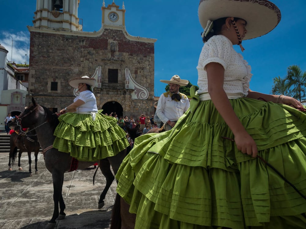 Cowgirls on their horses leave after the church mass.