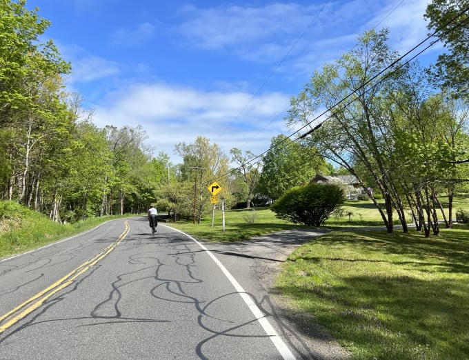 Lukas riding on a shared, windy, road in the countryside