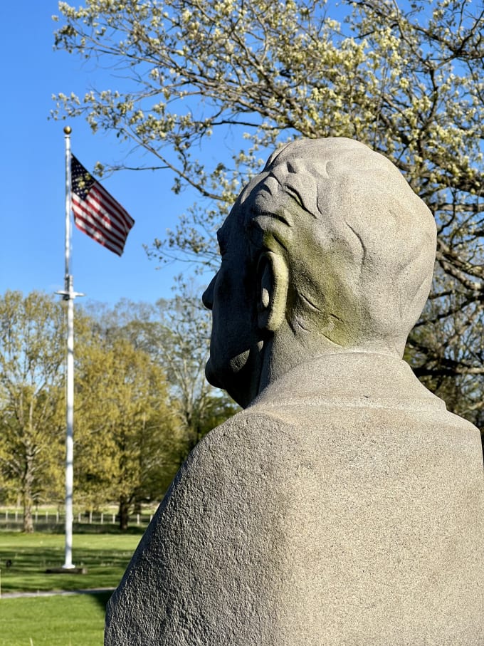 A bust of FDR with the American flag in the background