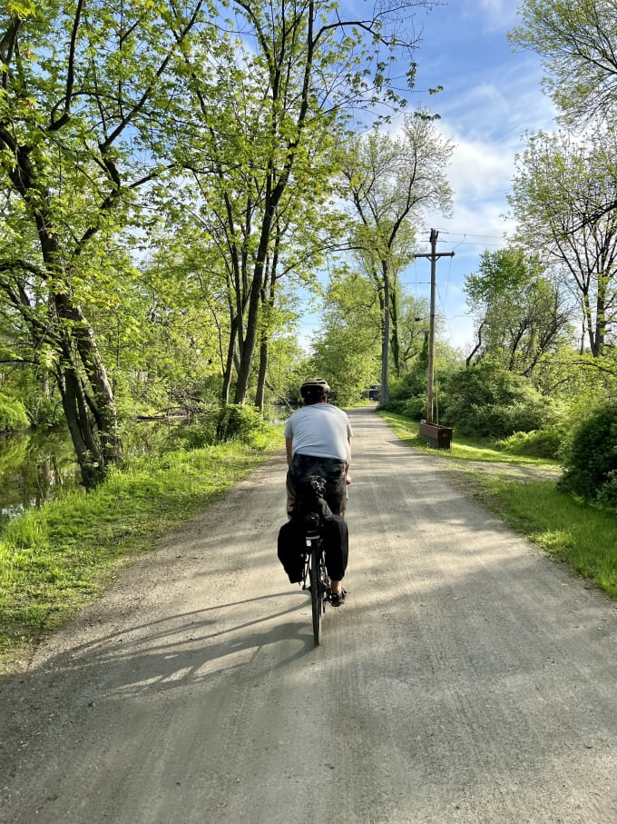 Lukas riding ahead on a dirt trail next to a river