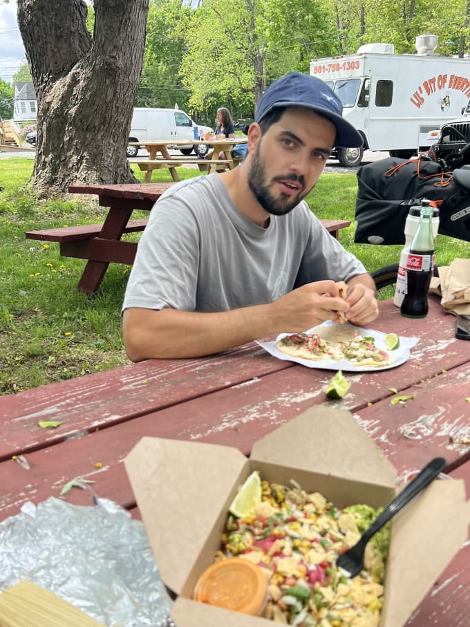 Danny eating tacos on a park bench