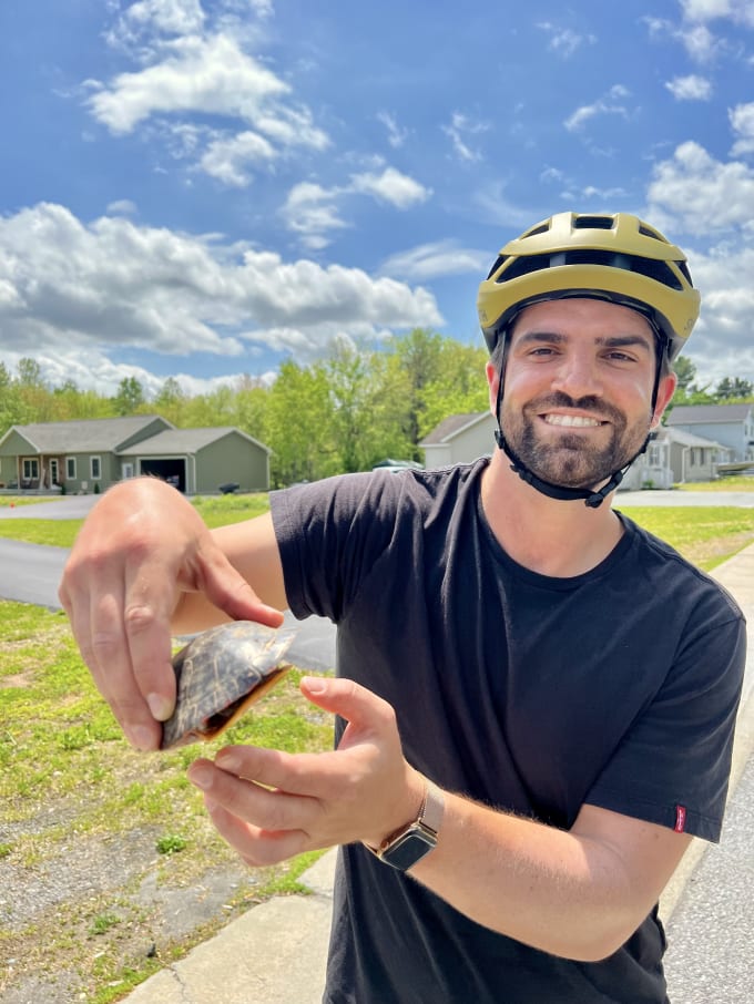 Lukas holding a turtle to the camera and smiling