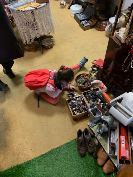 girl looking at buttons in antique shop