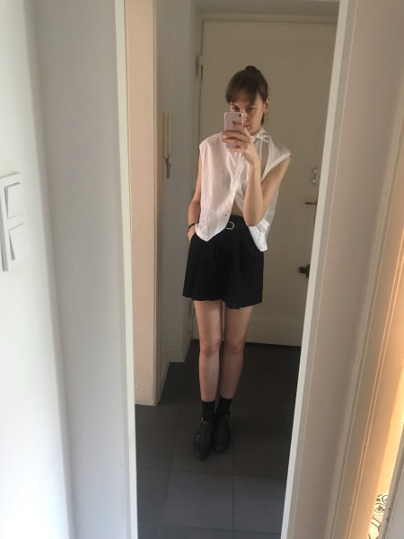 mirror selfie in shorts and white blouse