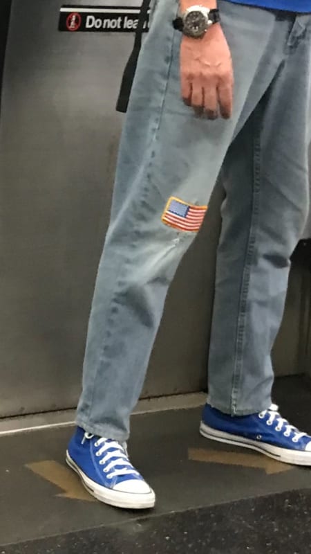 guy on train with american flag patch on jeans