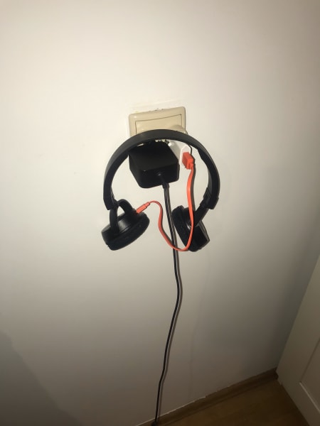 marilia's headphones balanced on photo charger in the socket