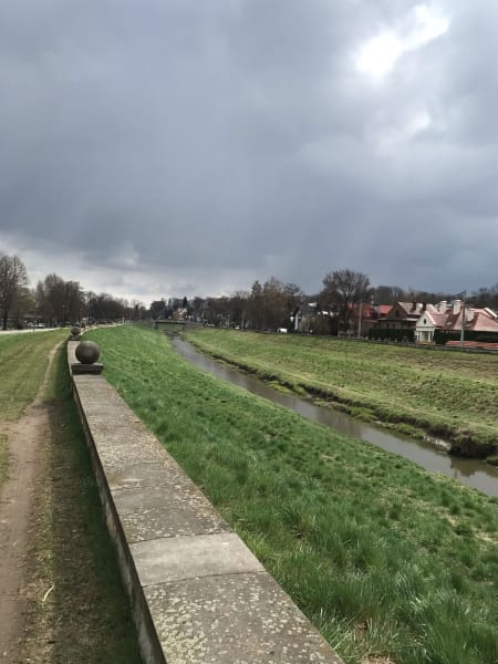 Grey sky green grass curving river