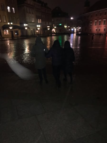 Dad and Ari and Holly walking linked arms in the rain at night