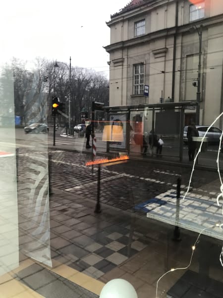 I think a restaurant or hotel lobby, has this strip of flam like a hovering fireplace?, photographed through glass, can see other things inside and many reflections from street