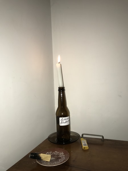 my side table with candle in a brown glass bottle