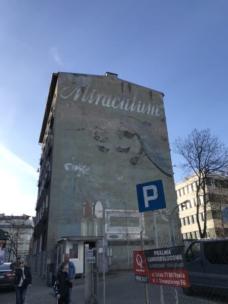 Building with faded old mural on it words seem ot say miraculum