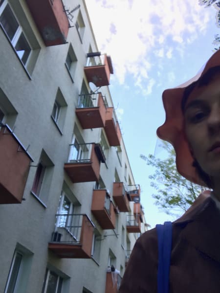 selfie in pink hat with pink balconies in background