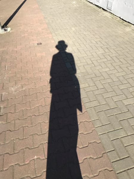 my shadow on ground notably wearing hat