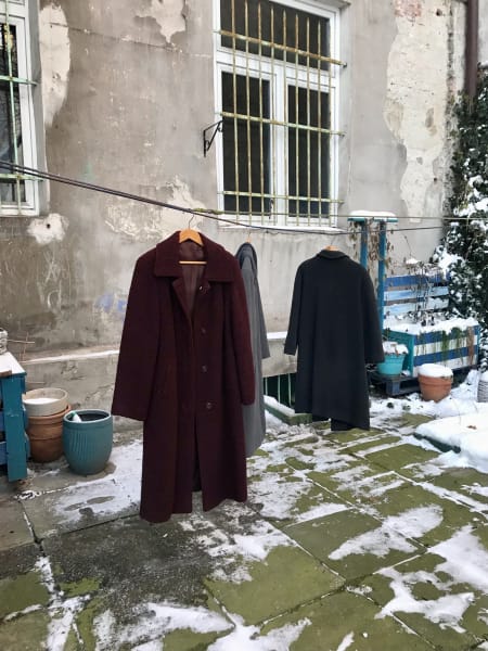 wool coats hanging in the back courtyard