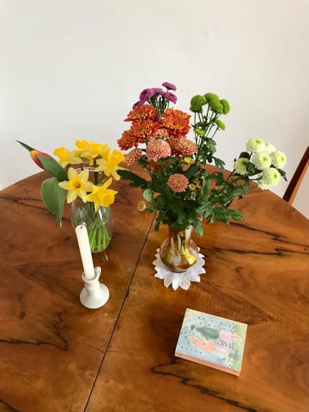 table with vases flowers candle and book