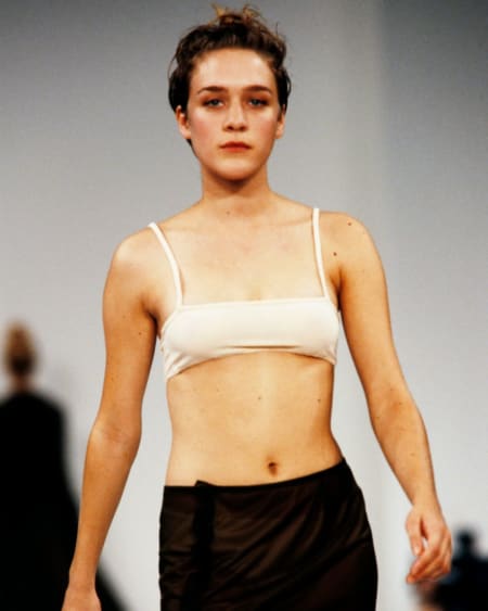Miu miu model in 90s with short blonde hair, cream bandeau bra and black slip skirt, a young Chloe Sevigny