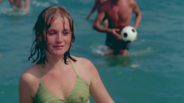 Screenshot of a young girl in green bikini coming out of the sea, a young Isabelle Huppert from The Lacemaker
