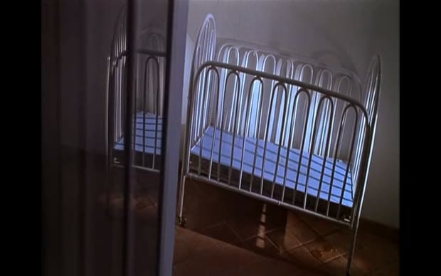 Werner Schroeter - Deux (2002), empty crib in corner of room