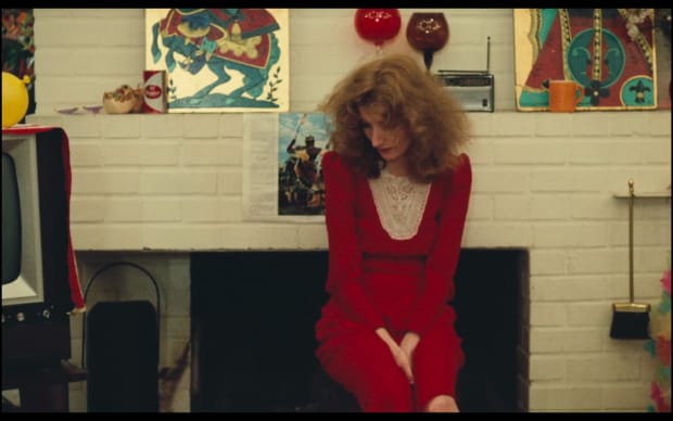 Agnes Varda - Lions Love (1969), Viva in red dress sitting looking forlorn