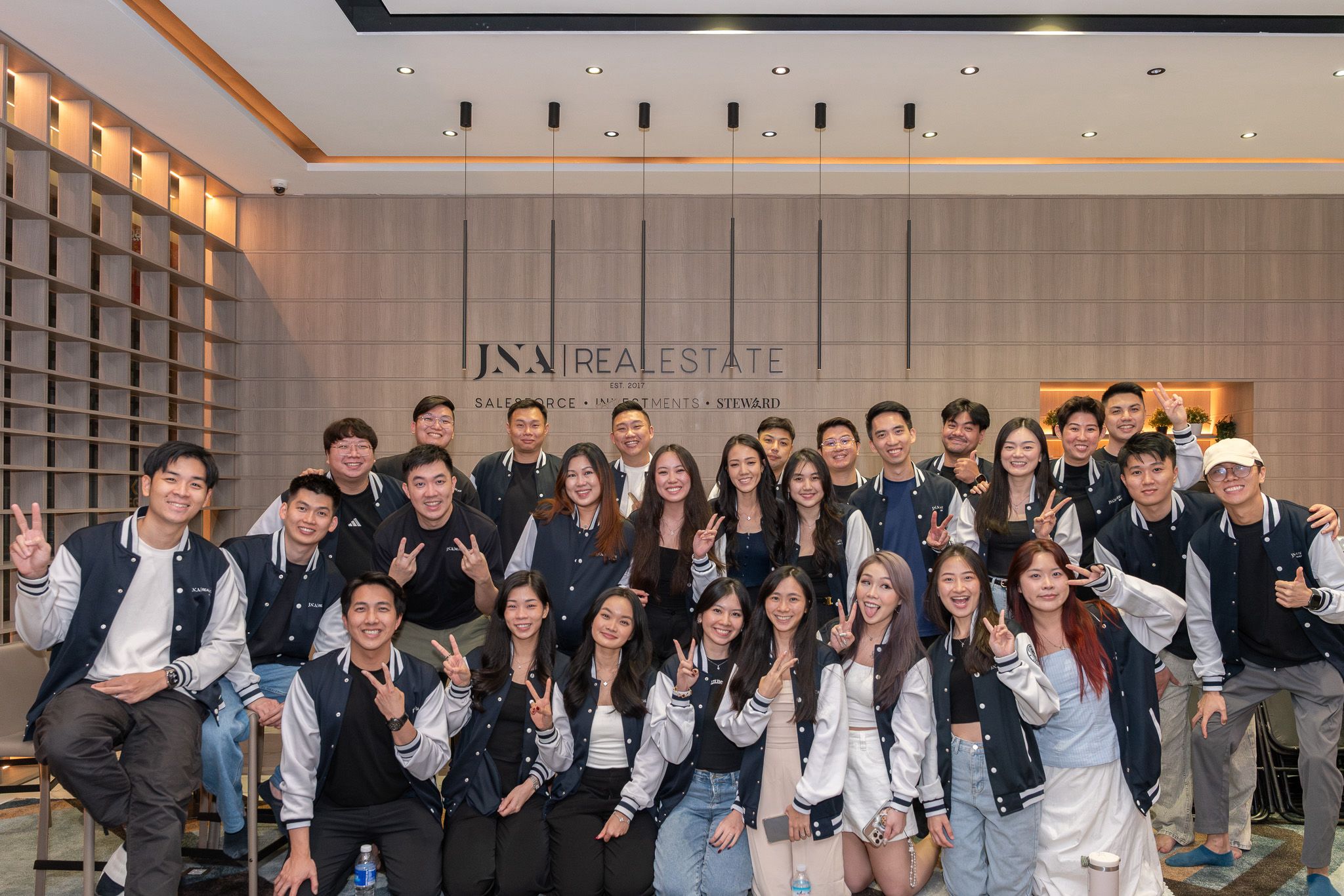 Team in varsity jackets at JNA office