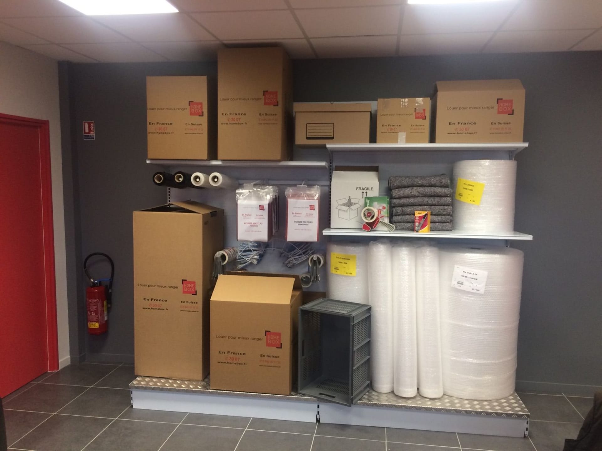 Espace boutique HOMEBOX Chalon-sur-Saône avec cartons, rubans adhésifs et matériel d’emballage.