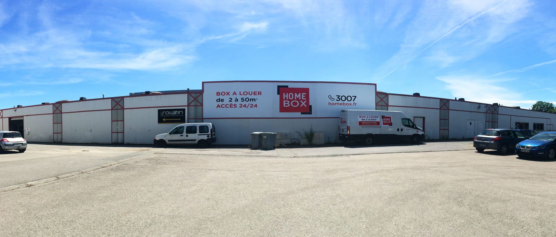 Façade extérieure avec enseigne HOMEBOX et utilitaires devant l'entrée du centre HOMEBOX Quimper Nord, 19 rue Nobel - Bât. 21 à Quimper