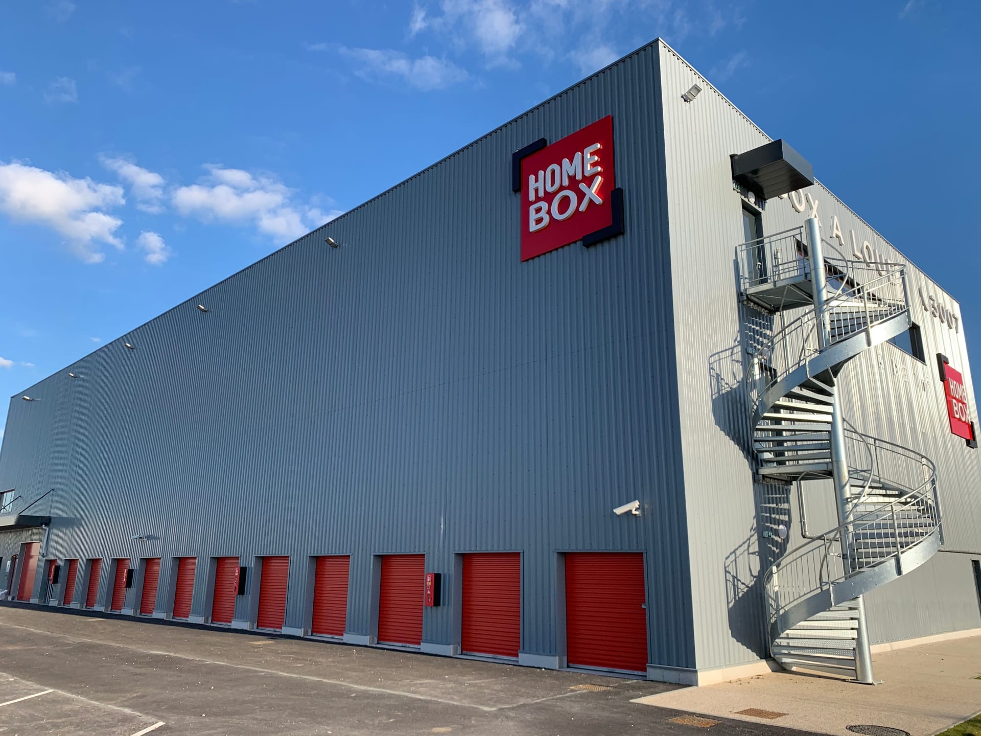 Façade du centre HOMEBOX Amiens - Glisy, rue Hector Servadac, avec alignement de box extérieurs et escalier métallique.