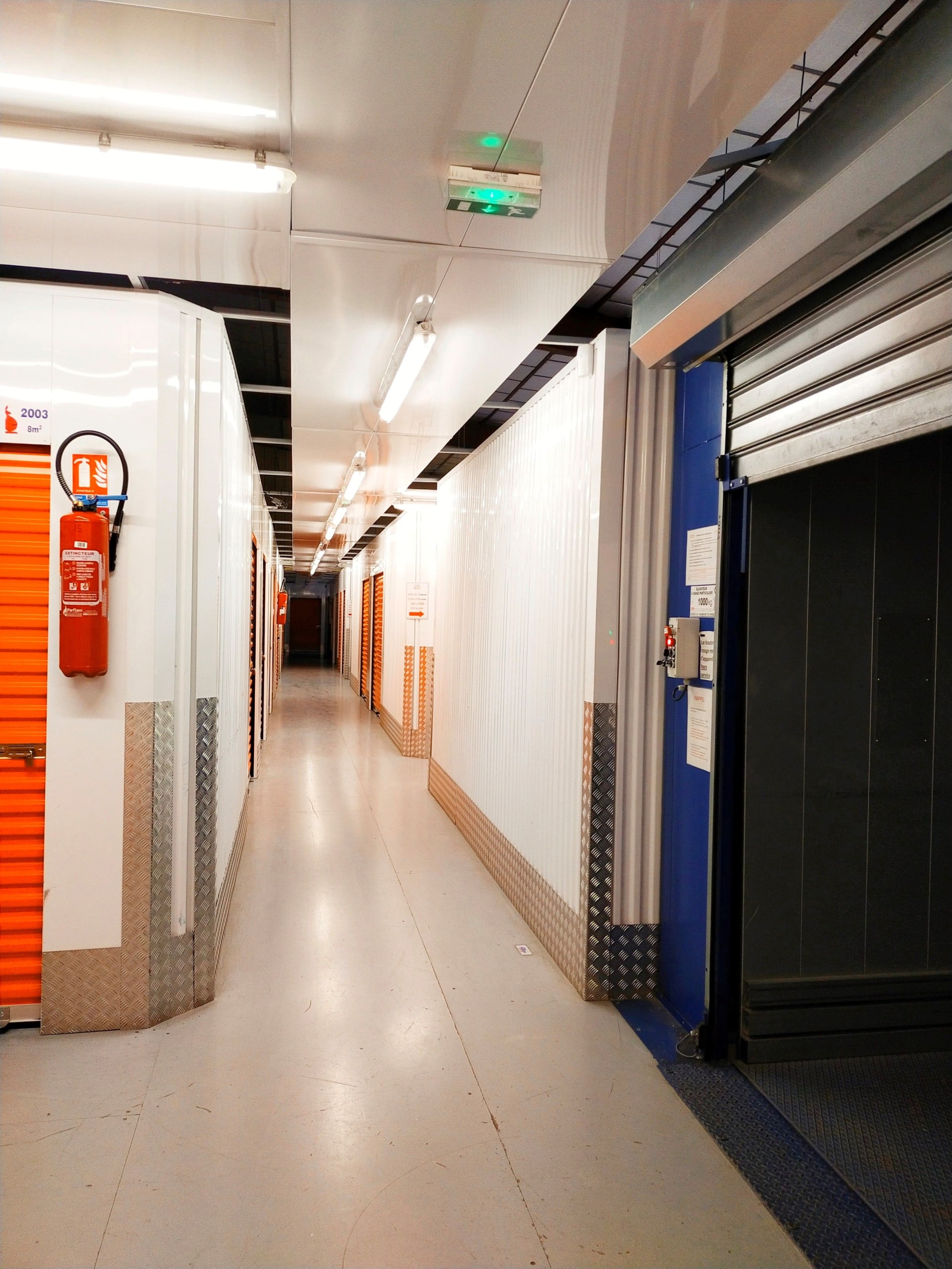 Couloir intérieur avec porte de box rouge et signalétique vidéosurveillance du centre HOMEBOX Maurepas