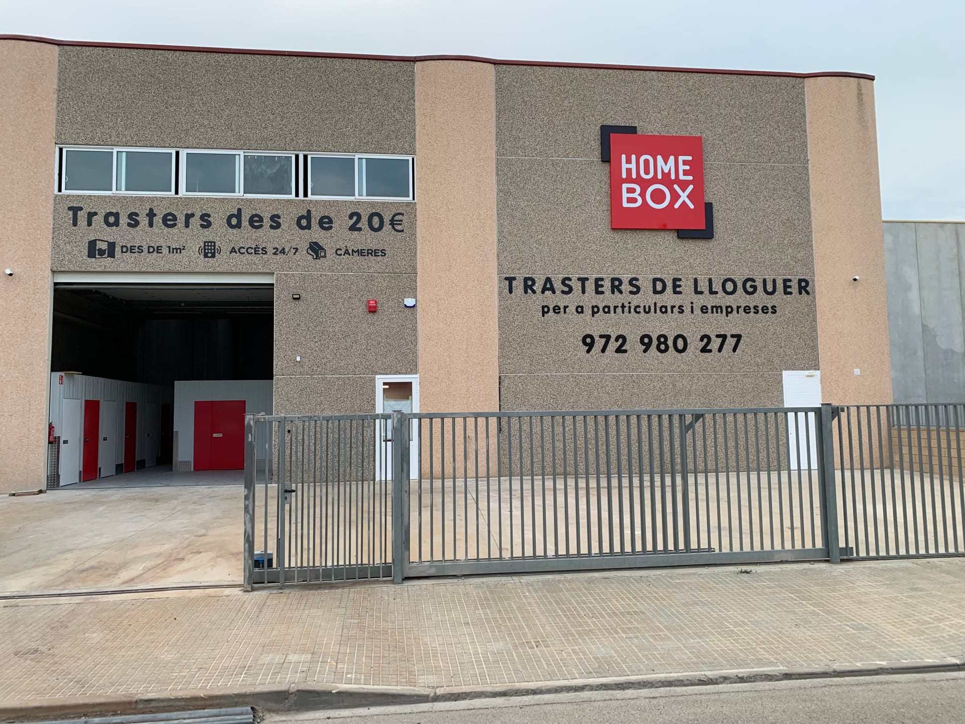 Façade avec quai de chargement ouvert et grille d'entrée fermée, HOMEBOX Roses, Carrer Ripollès, 27 Polígon Industrial El Pla à Castelló d'Empúries