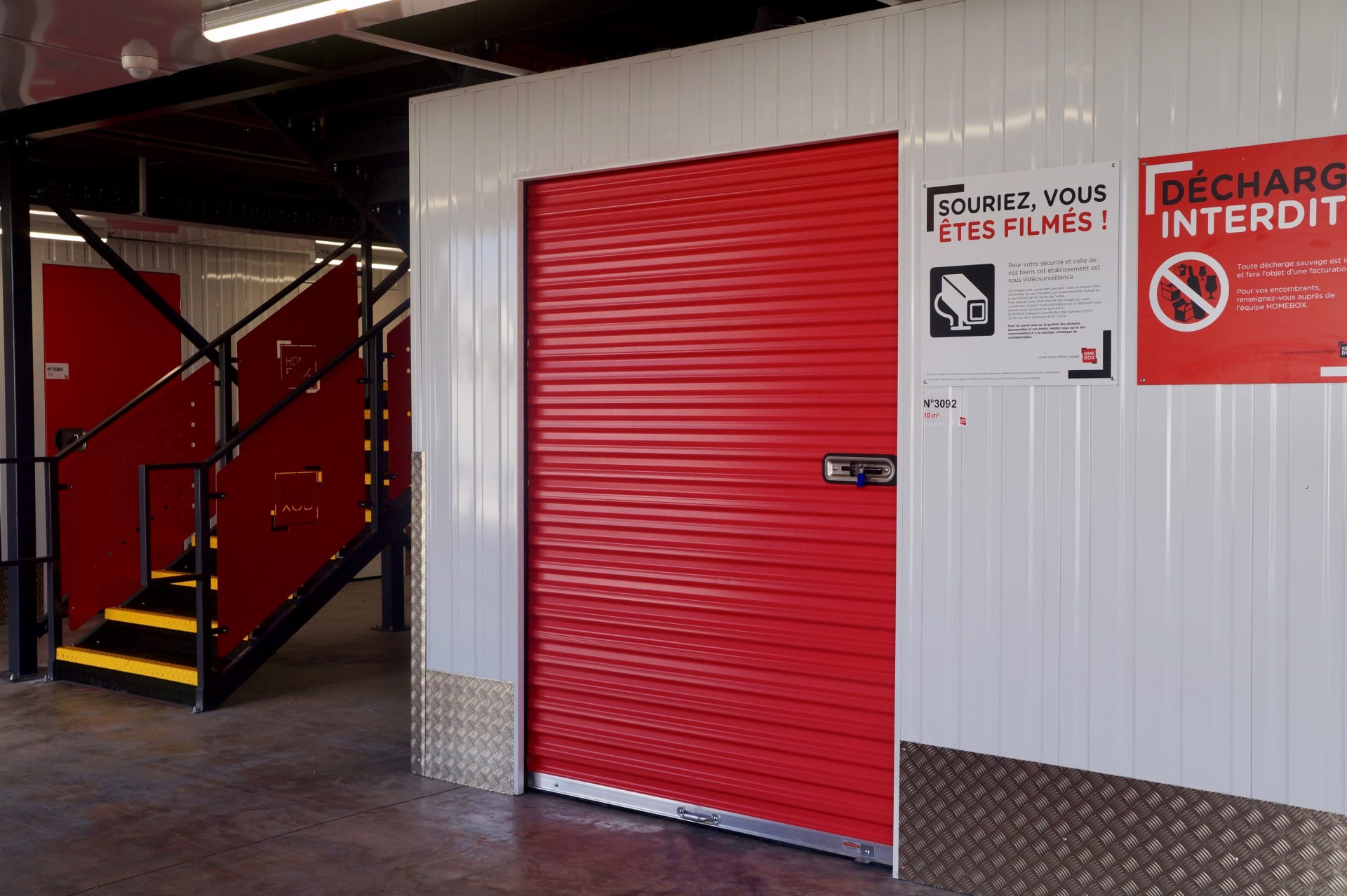 Box de stockage avec rideau rouge et escalier d'accès aux étages du centre HOMEBOX Montpellier