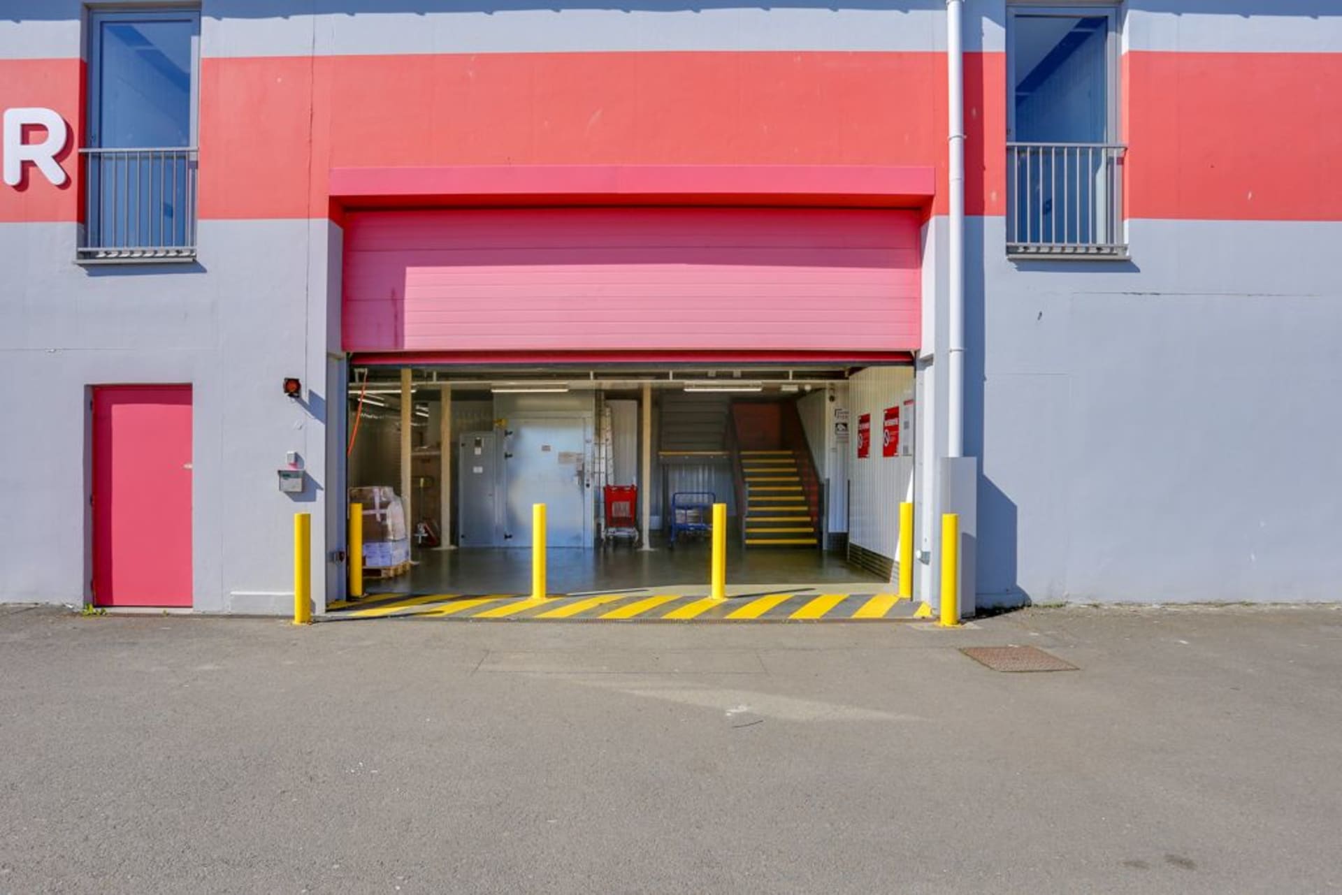 Quai de chargement avec rideau rouge ouvert, plots jaunes et accès intérieur, HOMEBOX Rennes Donelière, 10 rue Donelière à Rennes