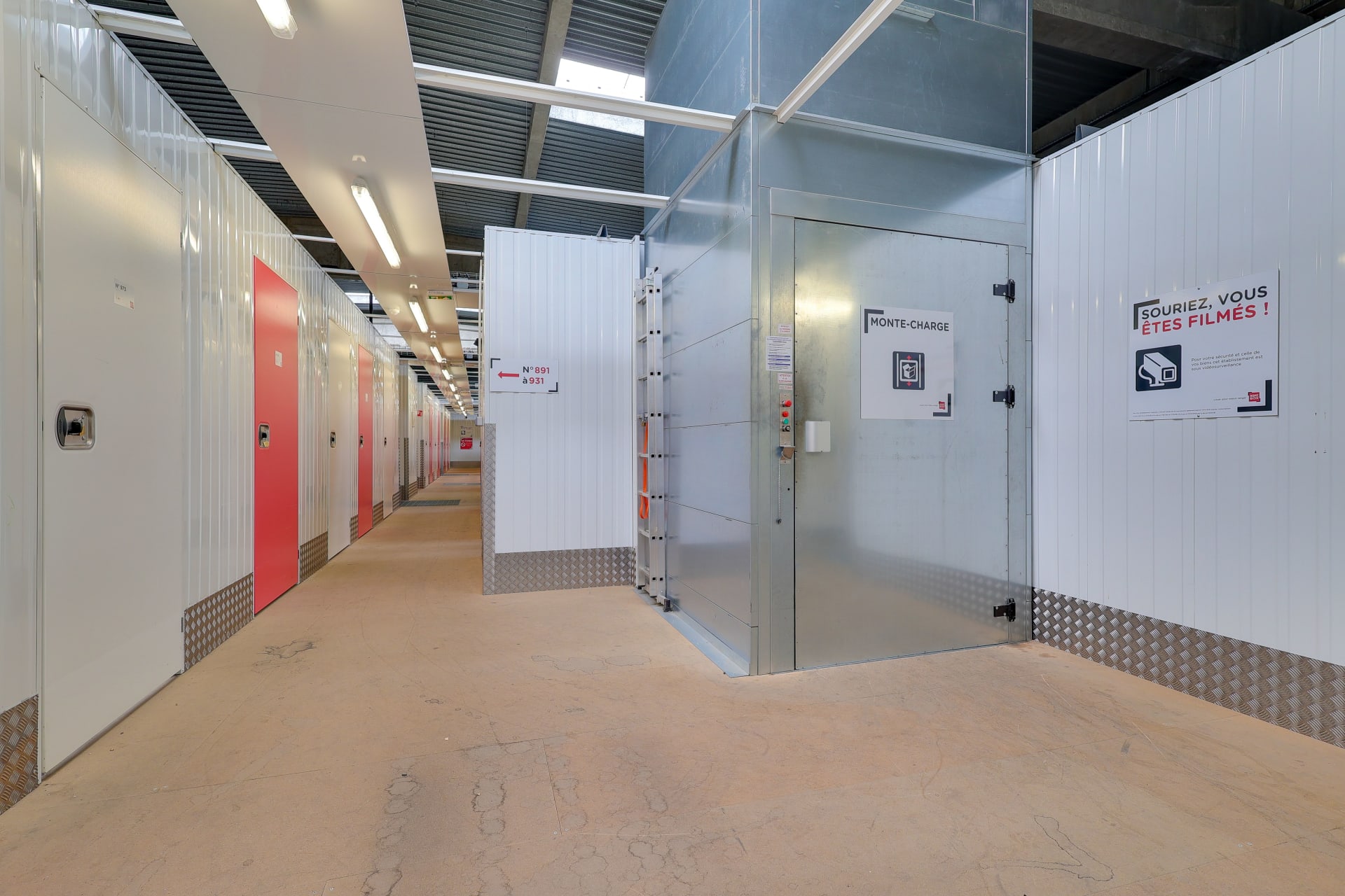 Zone intérieure avec monte-charge et accès aux couloirs de stockage signalés du centre HOMEBOX Toulouse Fondeyre