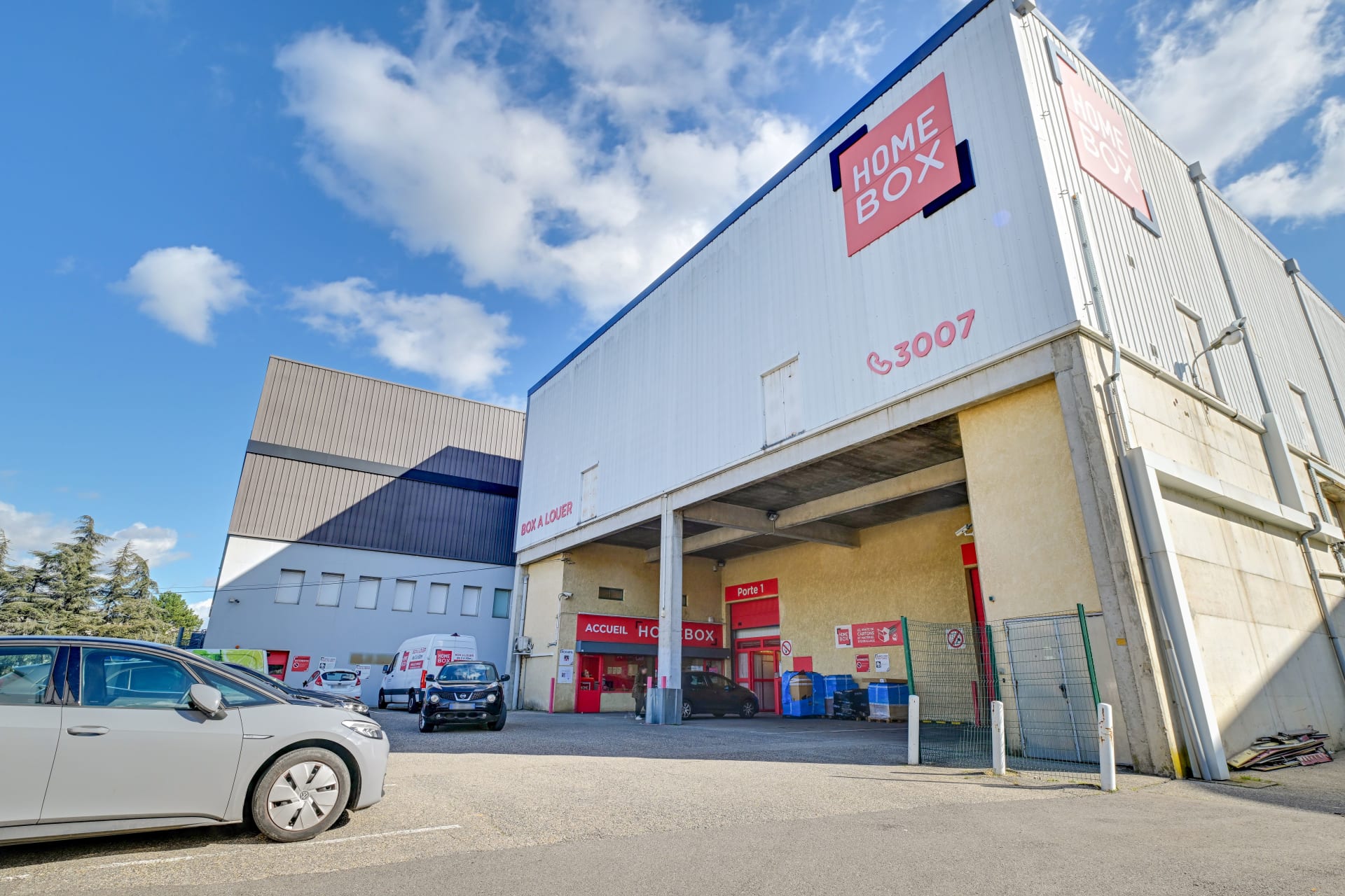 Façade du centre avec enseigne HOMEBOX et zone d'accueil sous le porche, HOMEBOX Lyon Ouest, 17 rue des Rosieristes à Champagne au Mont d'Or