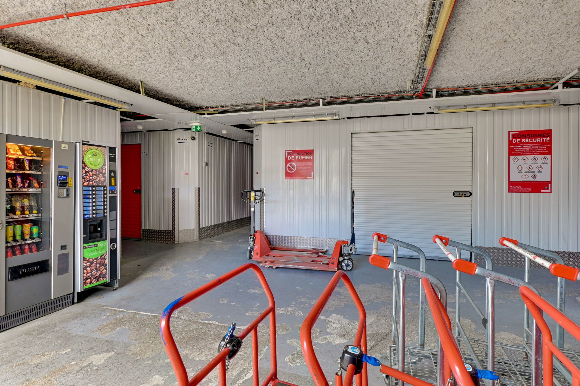 Zone intérieure avec distributeurs automatiques, chariots et porte de box du centre HOMEBOX Les Pennes-Mirabeau