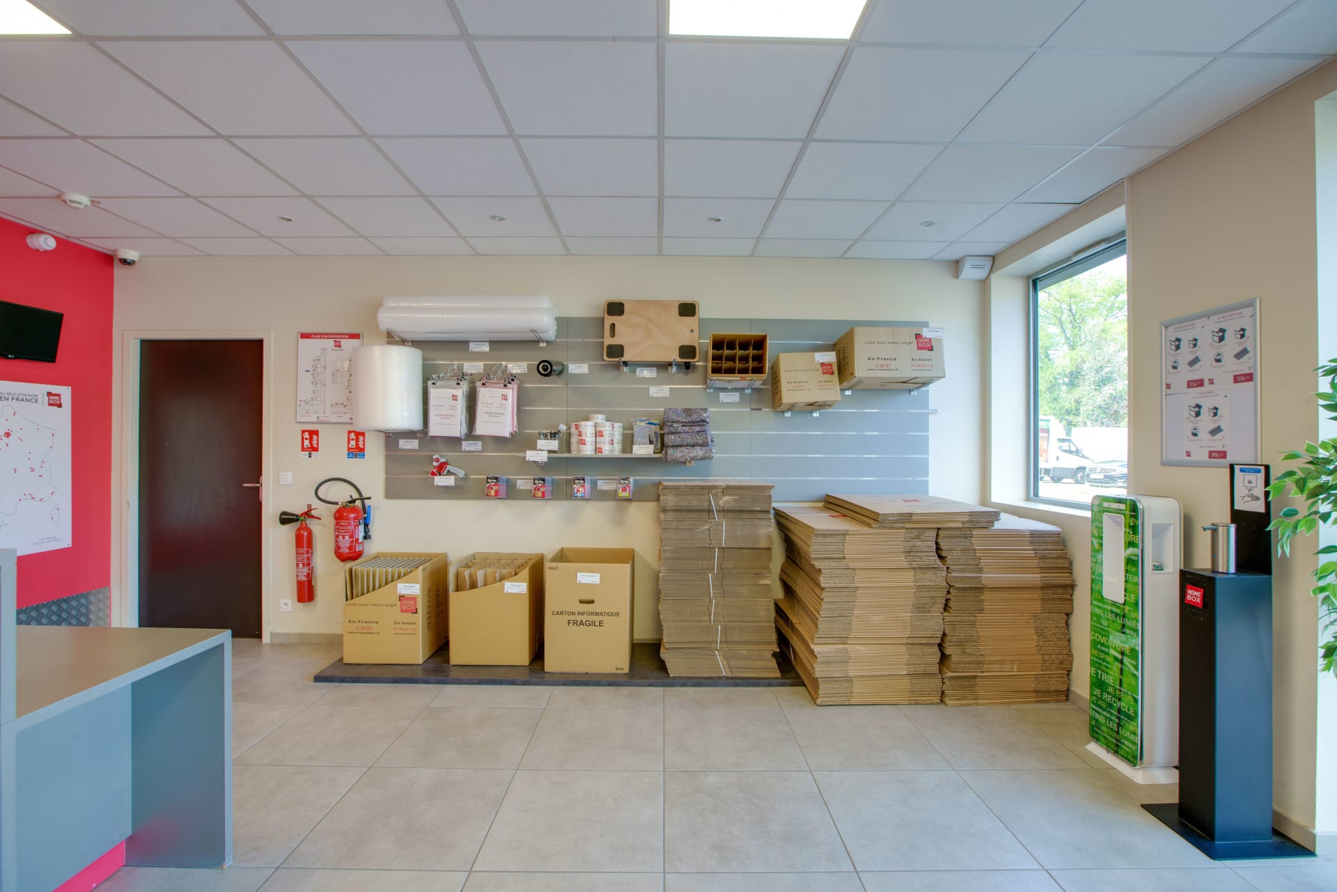 Espace de vente de fournitures au centre HOMEBOX Grenoble avec cartons empilés et matériel d’emballage.