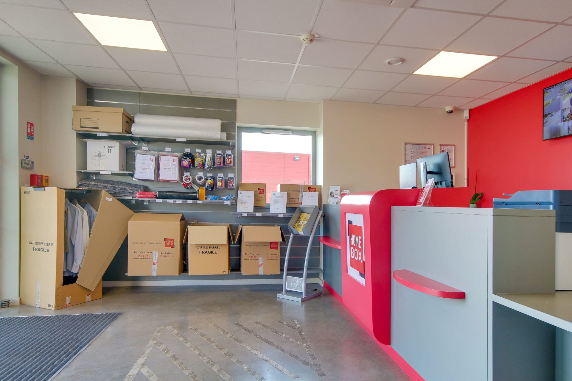 Espace boutique avec cartons penderie, fournitures d'emballage et comptoir d'accueil du centre HOMEBOX Reims Nord