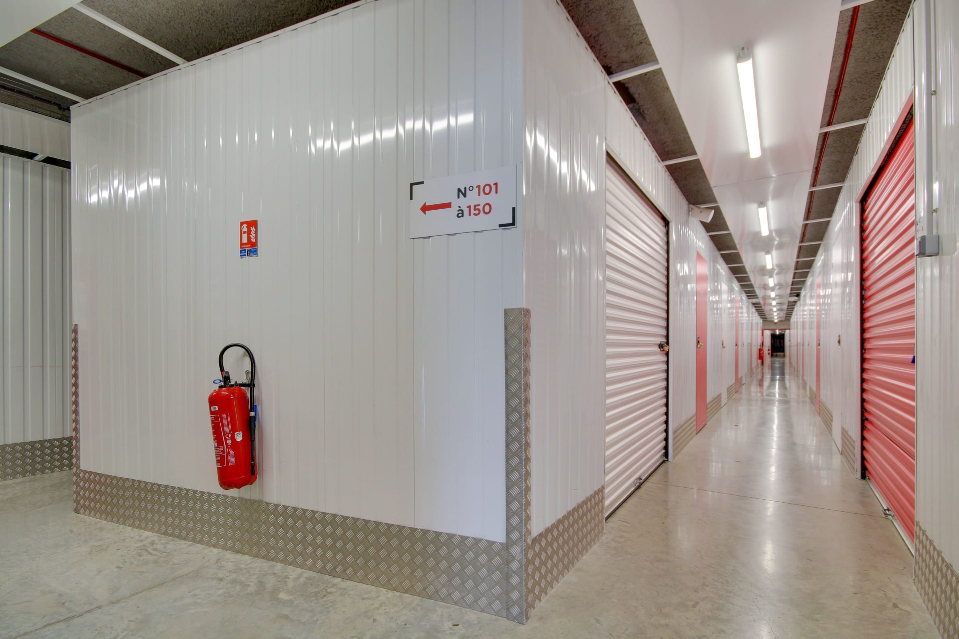 Couloir d'étage avec signalétique des numéros de box et extincteur du centre HOMEBOX Reims Nord