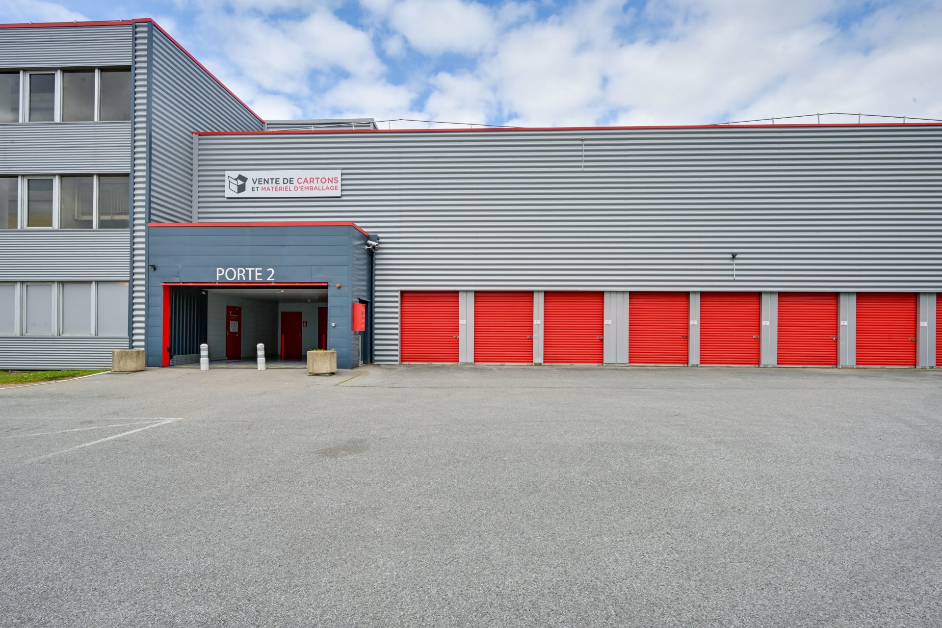 Bâtiment gris avec rangée de box rouges et entrée porte 2, HOMEBOX Plaisir, 15 rue Descartes à Plaisir