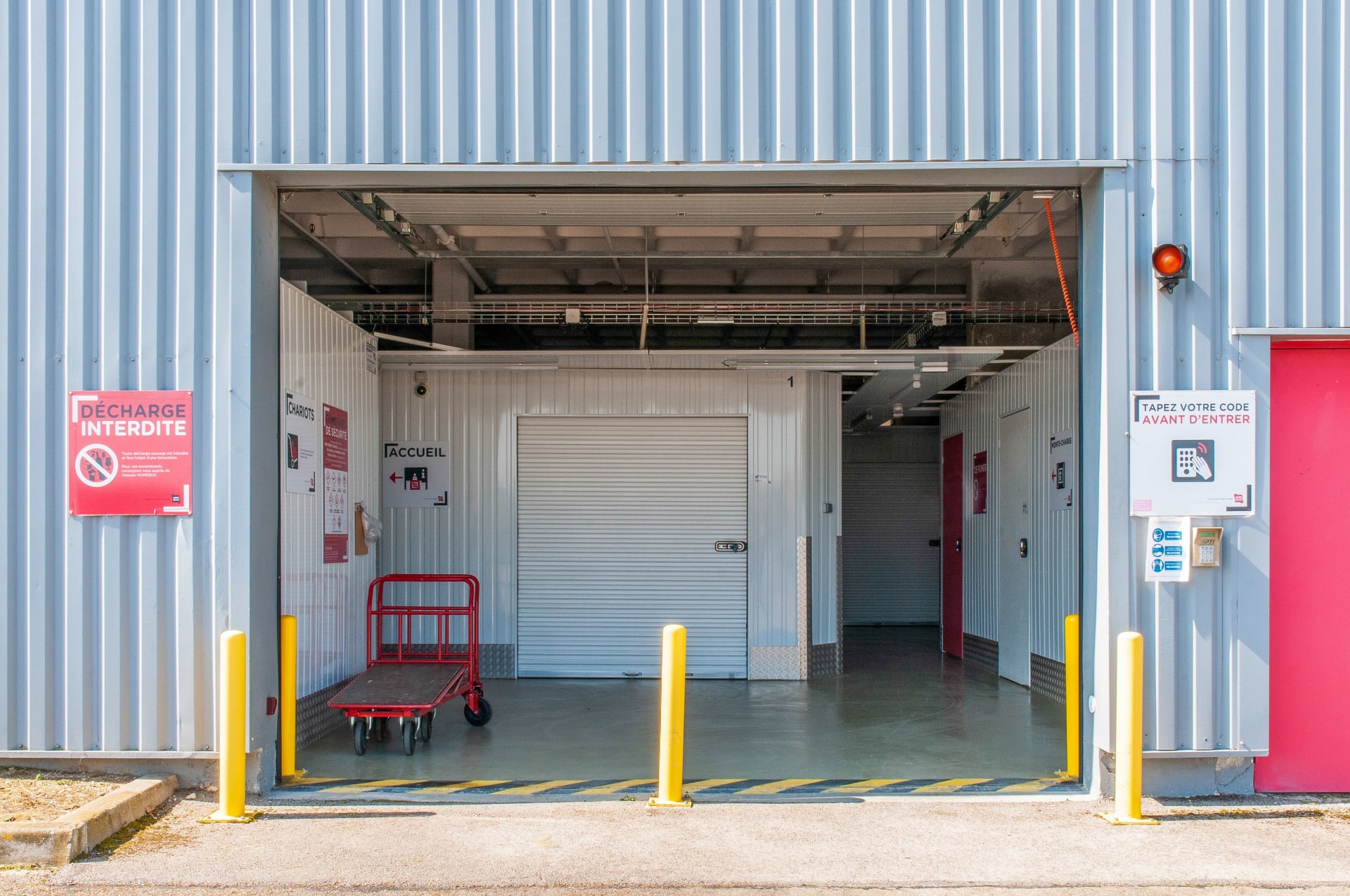 Sas d'accès extérieur avec rideau métallique et chariot rouge, HOMEBOX Troyes, 2 à 10 rue Maryse Bastié à Barberey-Saint-Sulpice