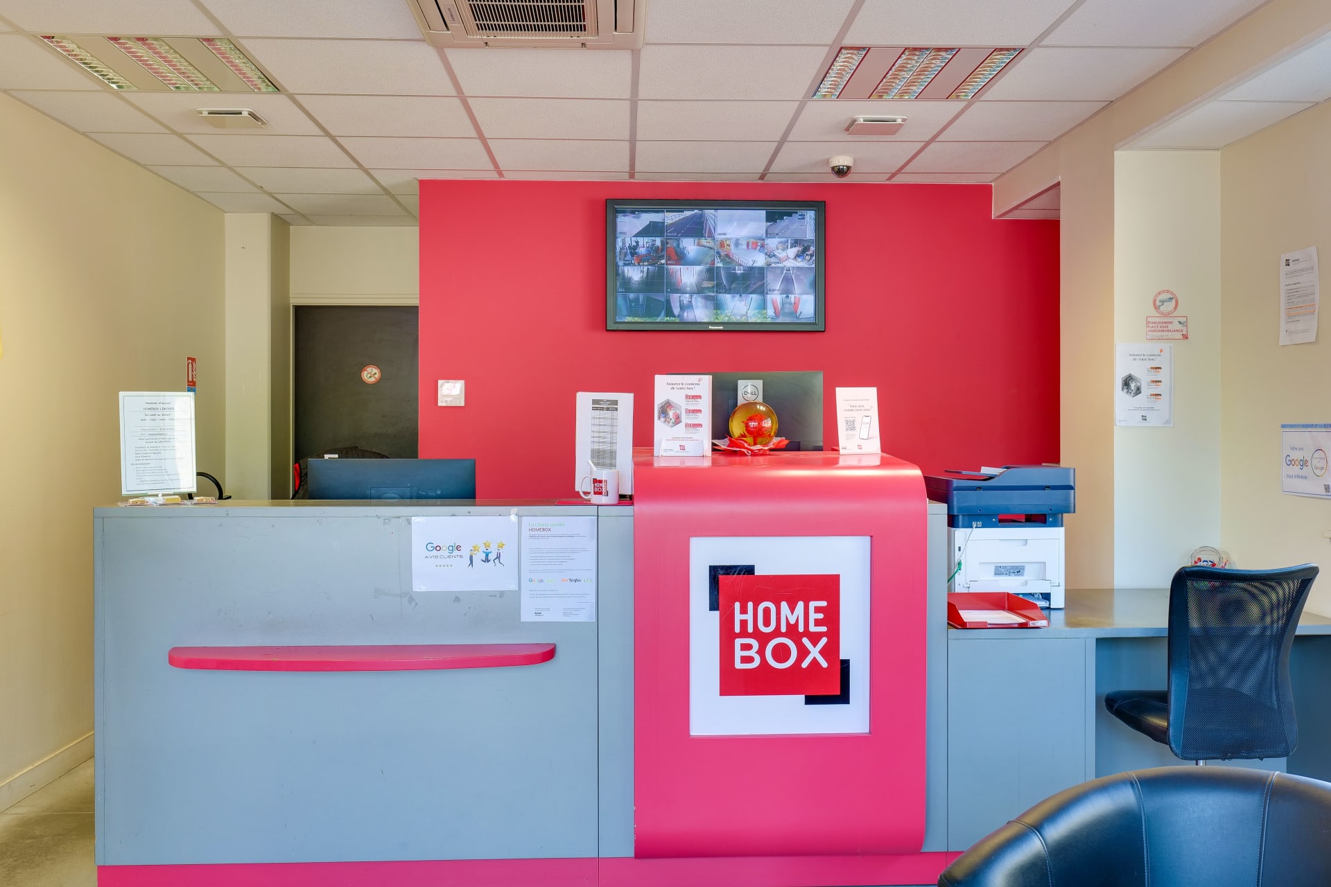 Comptoir d'accueil rose avec écran de vidéosurveillance du centre HOMEBOX Limoges
