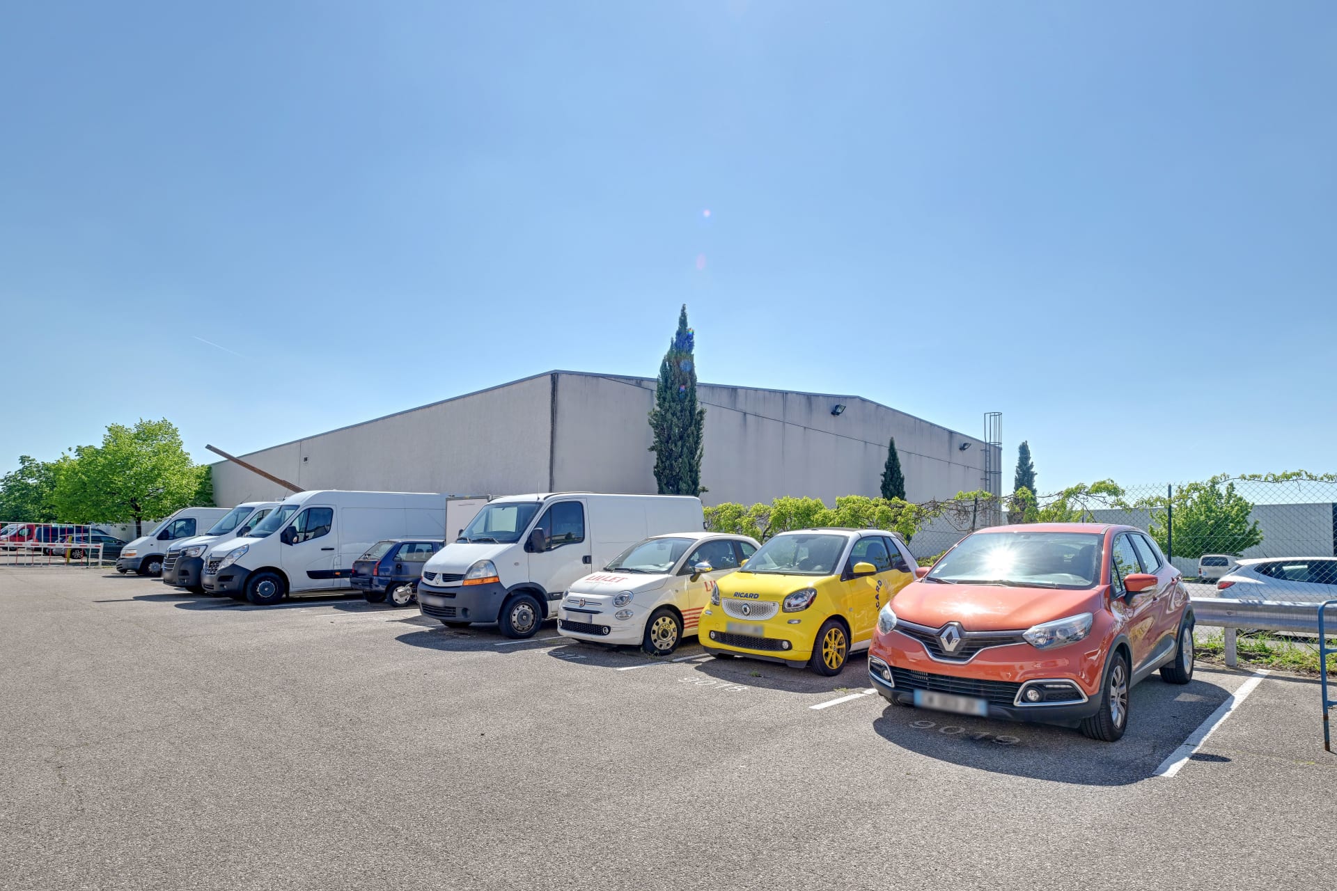 Parking extérieur avec camions et véhicules de location stationnés, HOMEBOX Lyon Décines-Villeurbanne, 21 rue Emile Zola à Décines-Charpieu