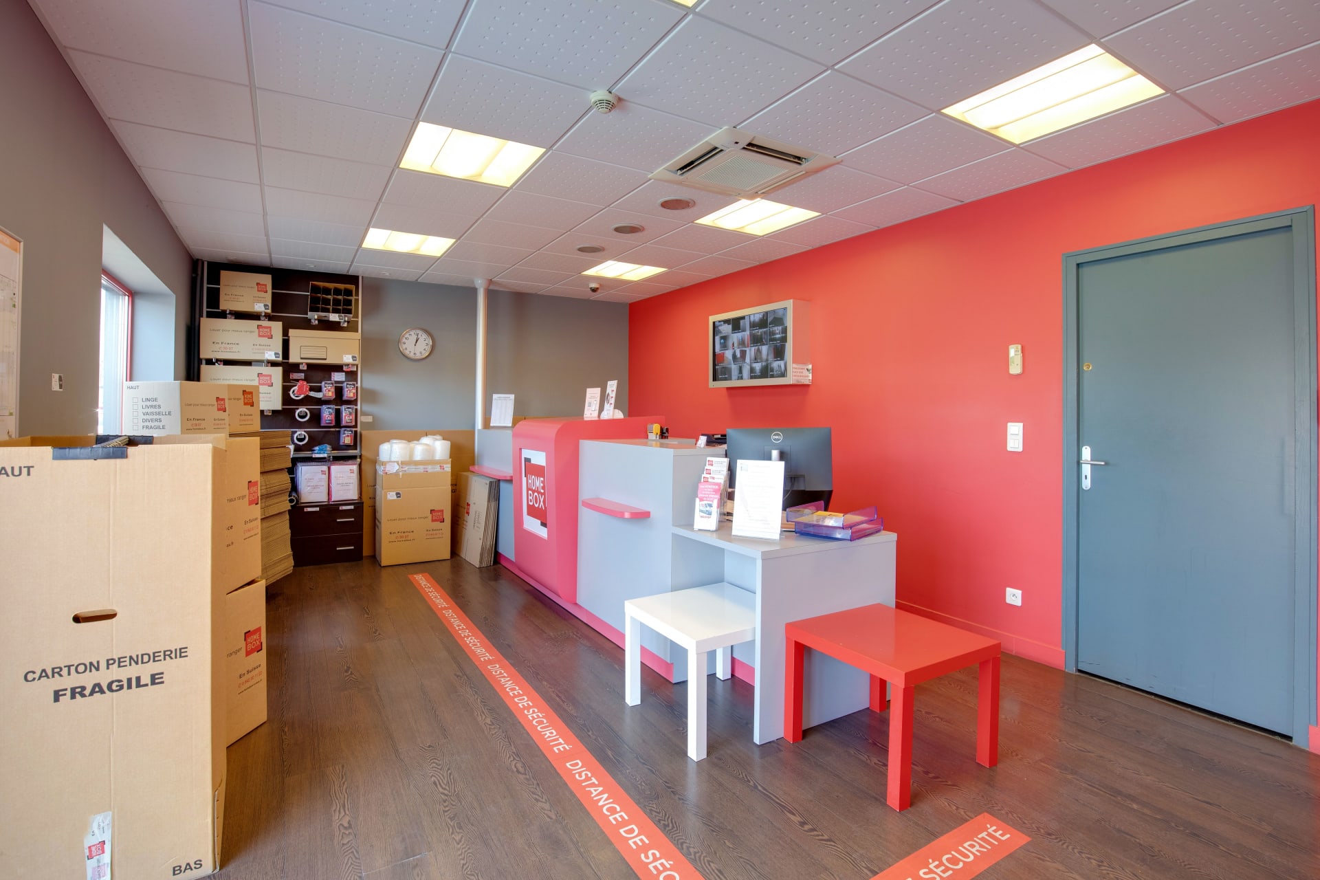 Accueil intérieur avec comptoir rose HOMEBOX, cartons de déménagement et marquage au sol distance de sécurité du centre HOMEBOX Le Havre